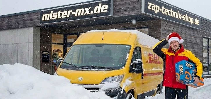 DHL-Fahrer im Schnee vor einem Geschäft